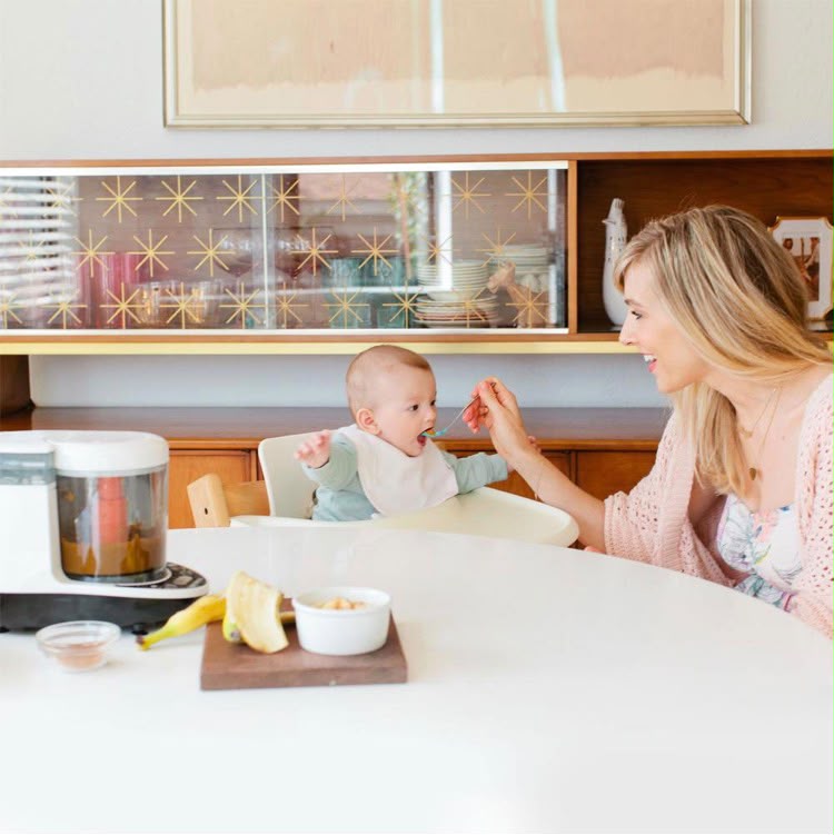 Un parent prépare un repas pour bébé avec un robot cuiseur